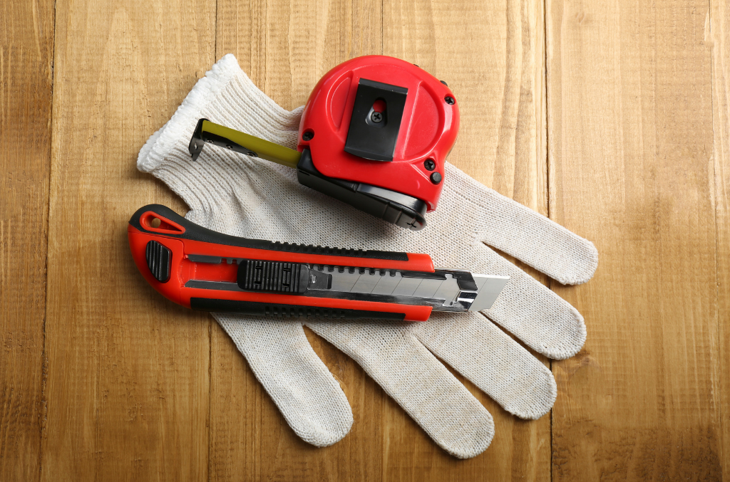 a picture of white cut resistant gloves and a cutter and some tape measure